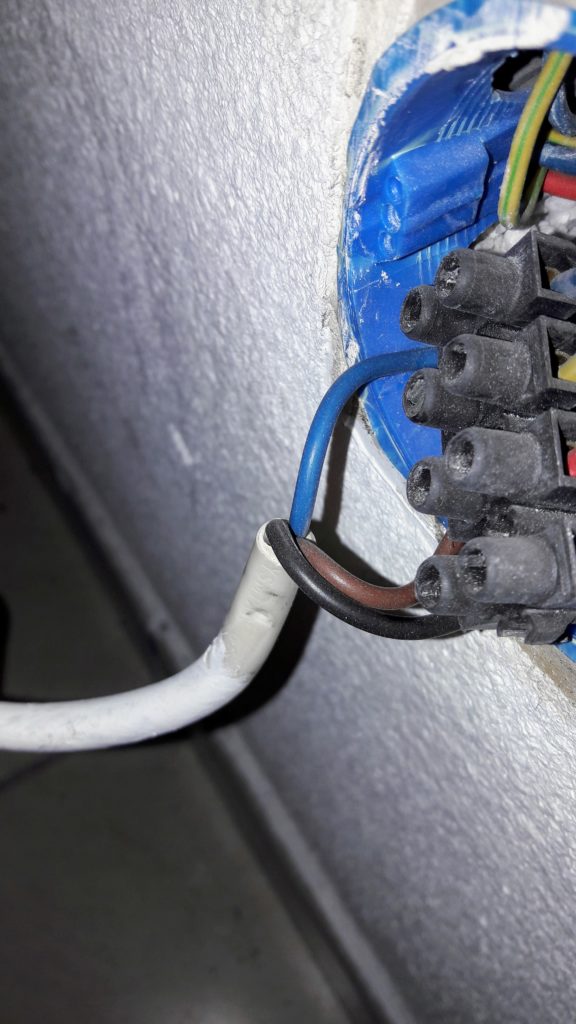 Câble du radiateur vers le mur. On peut voir trois câbles : un bleu, un marron et un noir